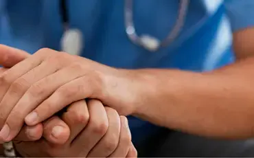 Doctor holding patient's hand
