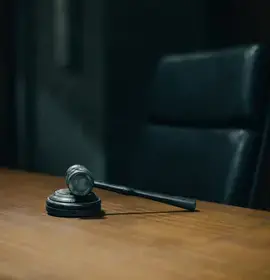 A Resting Gavel on a Table with Black Chair