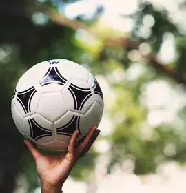 Person's Hand Holding Football in the Air