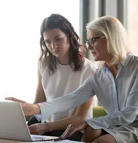 Serious middle aged executive manager explaining colleague online work together pointing at laptop, mature older financial advisor insurer or bank worker making offer to client