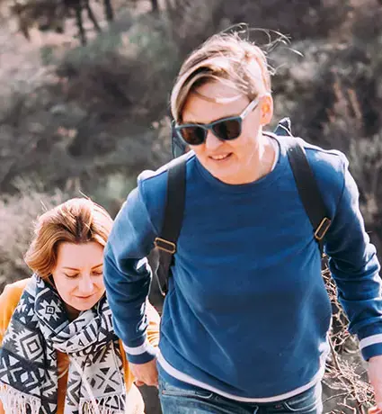 Happy lesbian couple walking on a hill