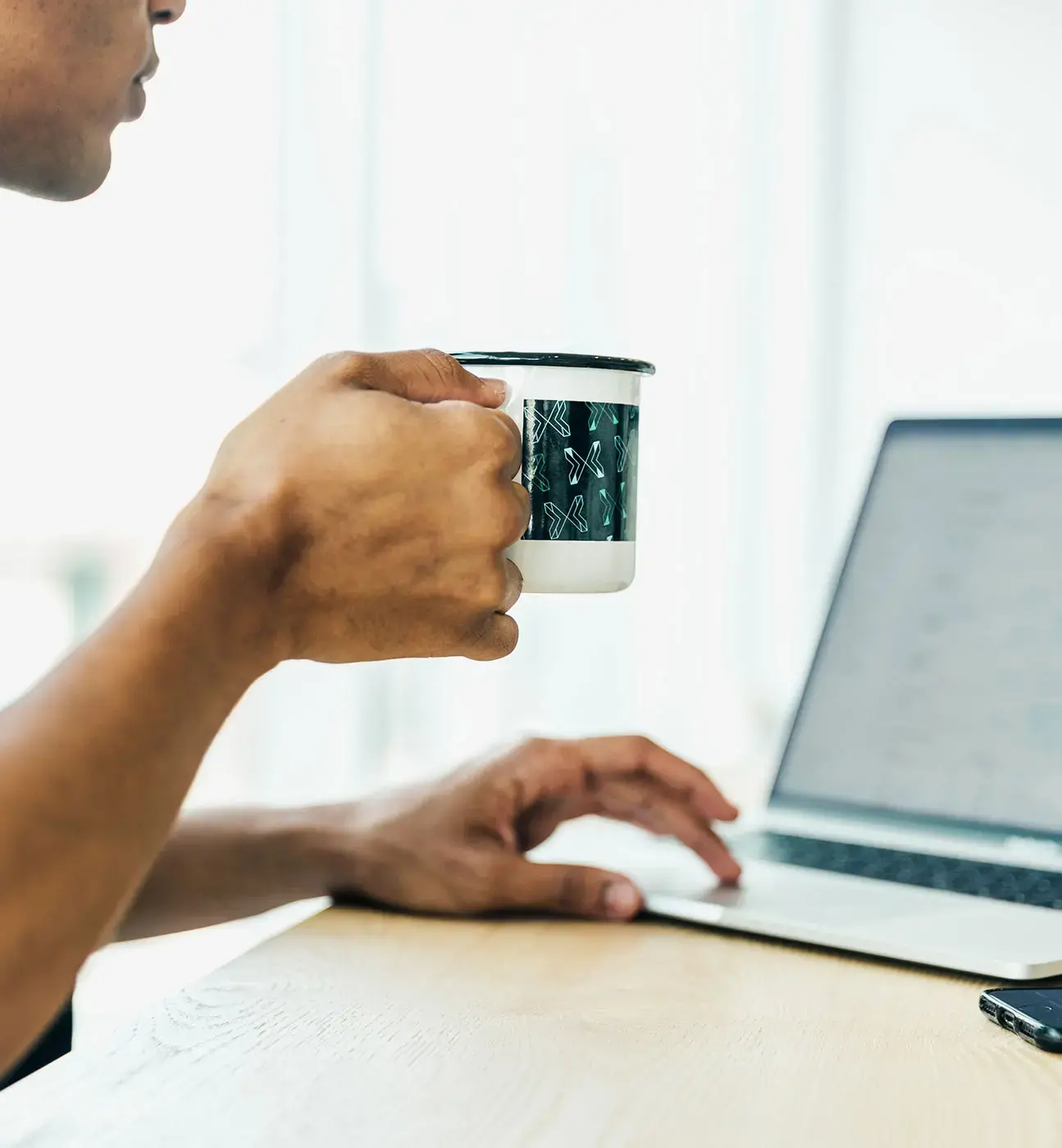 man-at-computer-looking-at-graphs-drinking-coffee