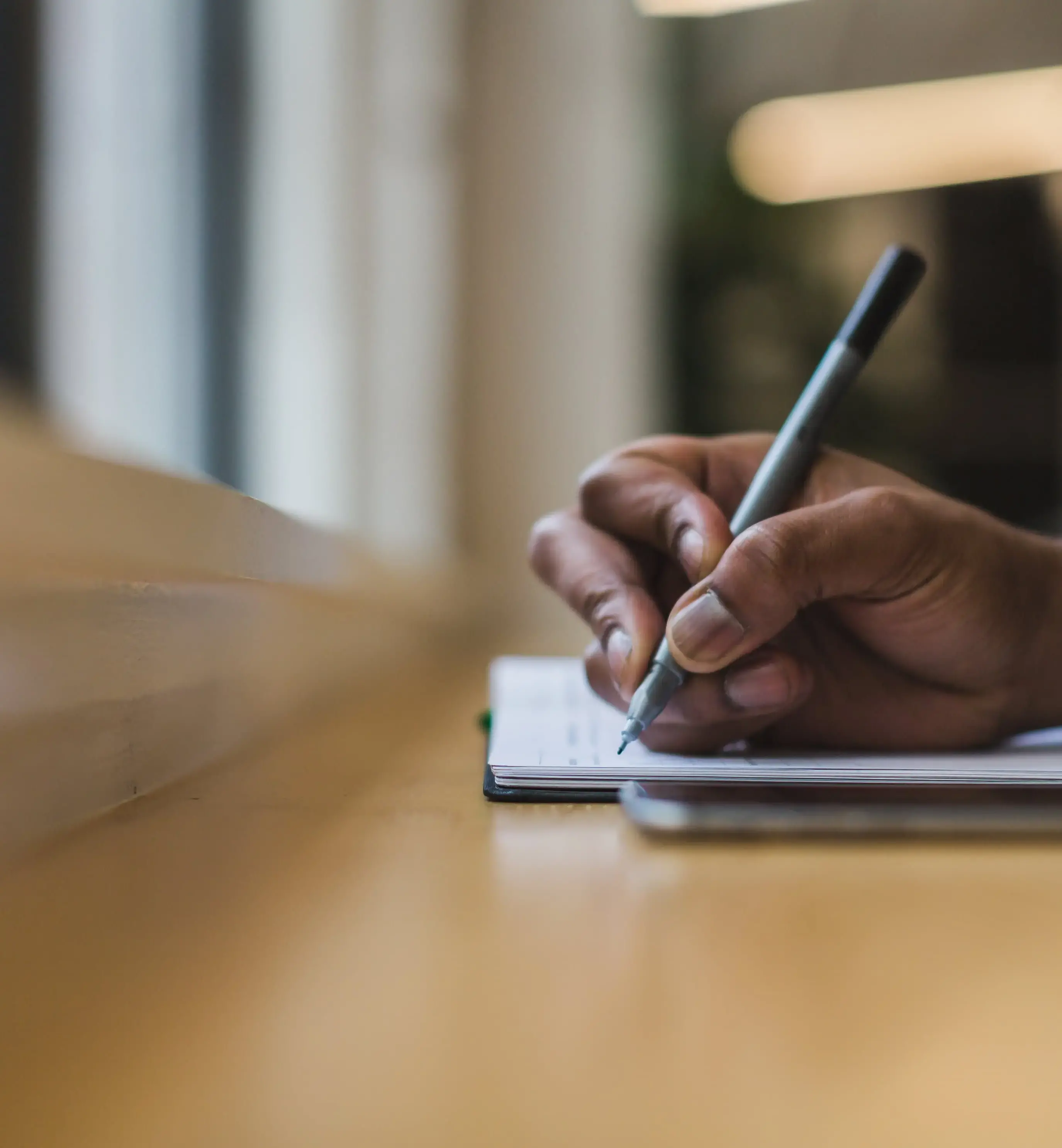 Person Writing in Note Pad with Pen