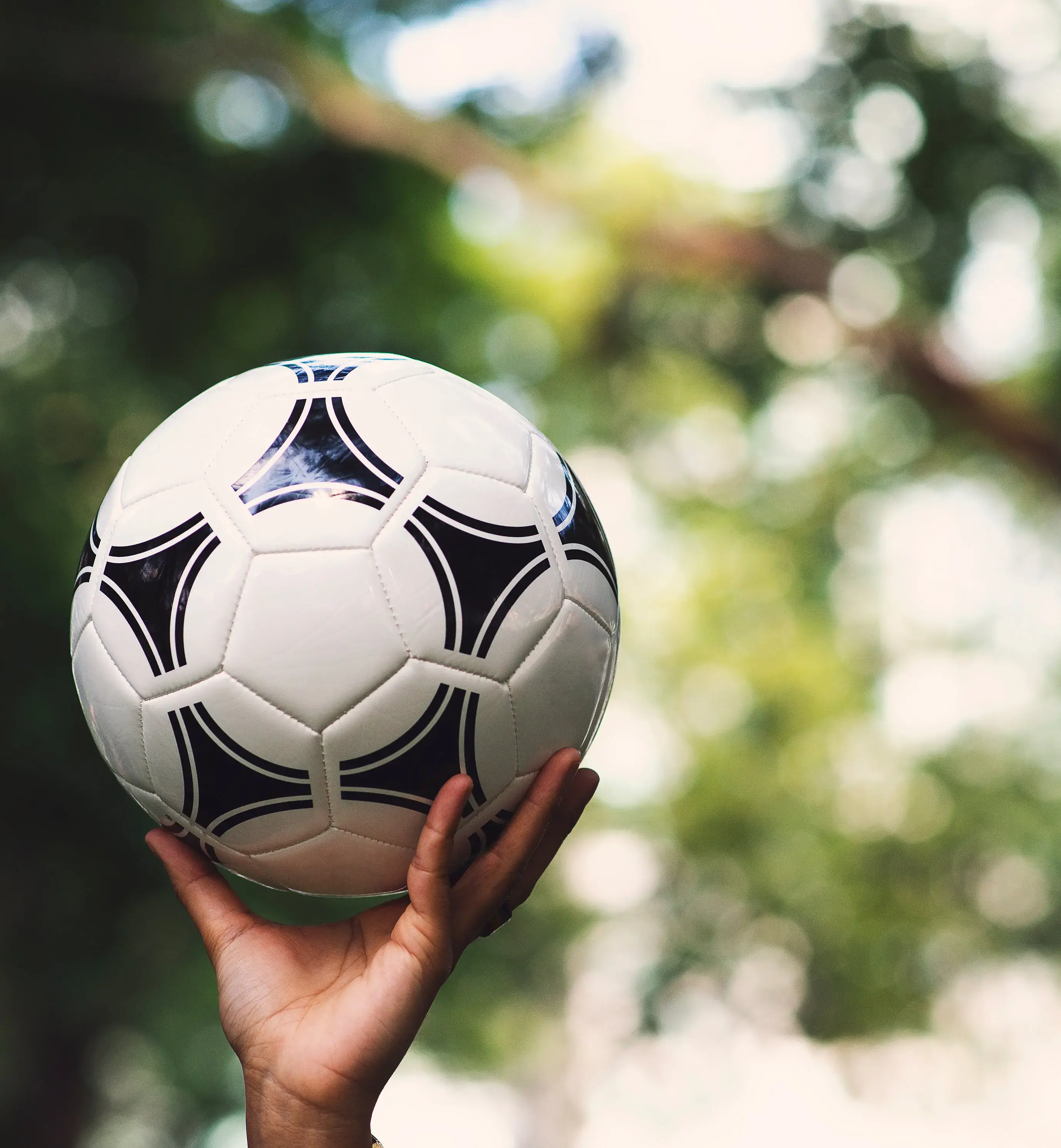 Person's Hand Holding Football in the Air