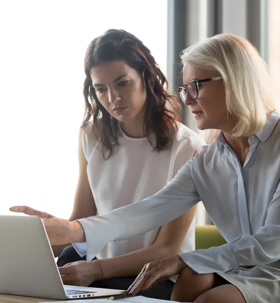 Serious middle aged executive manager explaining colleague online work together pointing at laptop, mature older financial advisor insurer or bank worker making offer to client