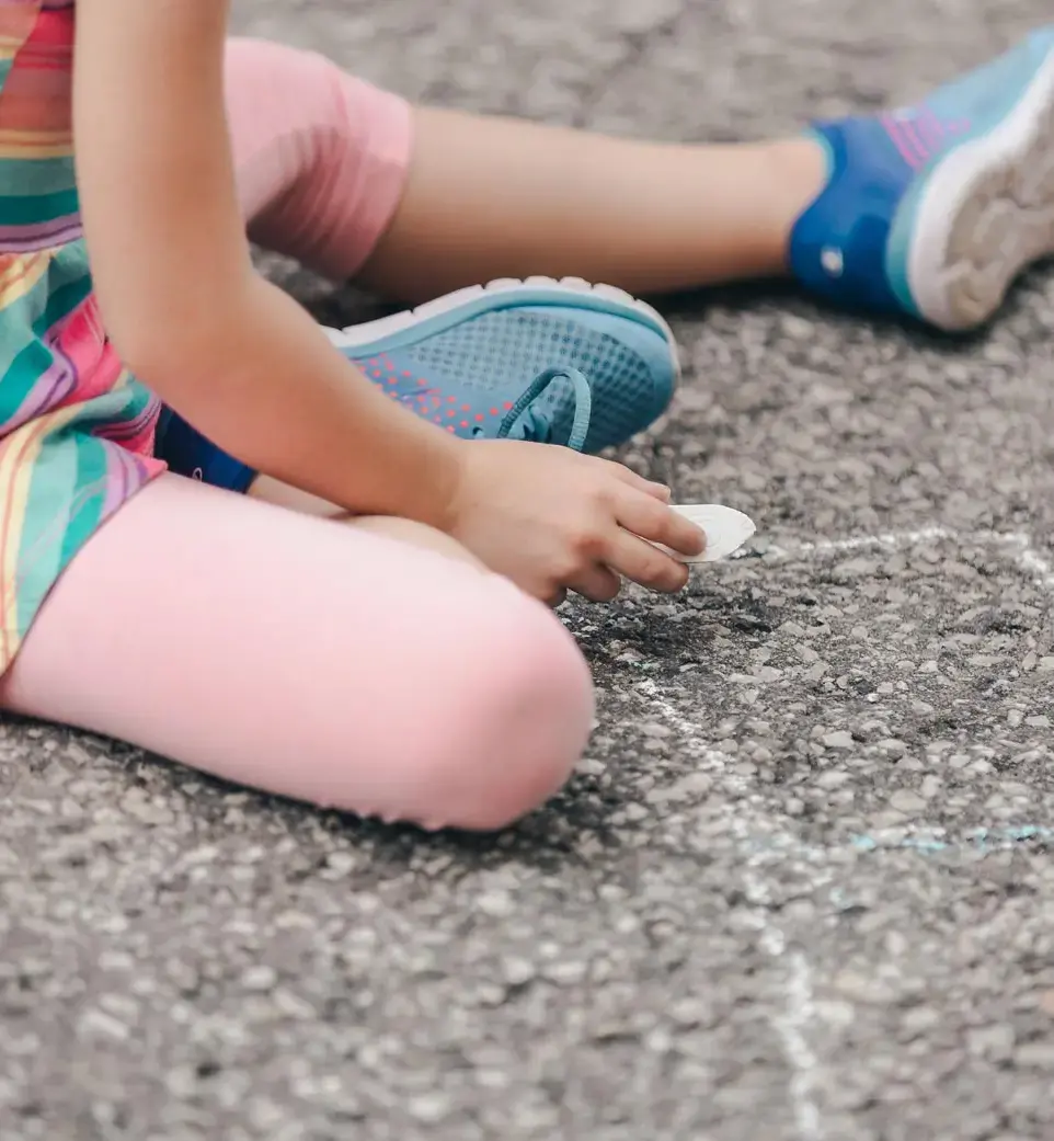 Child Drawing on Pavement with Chalk