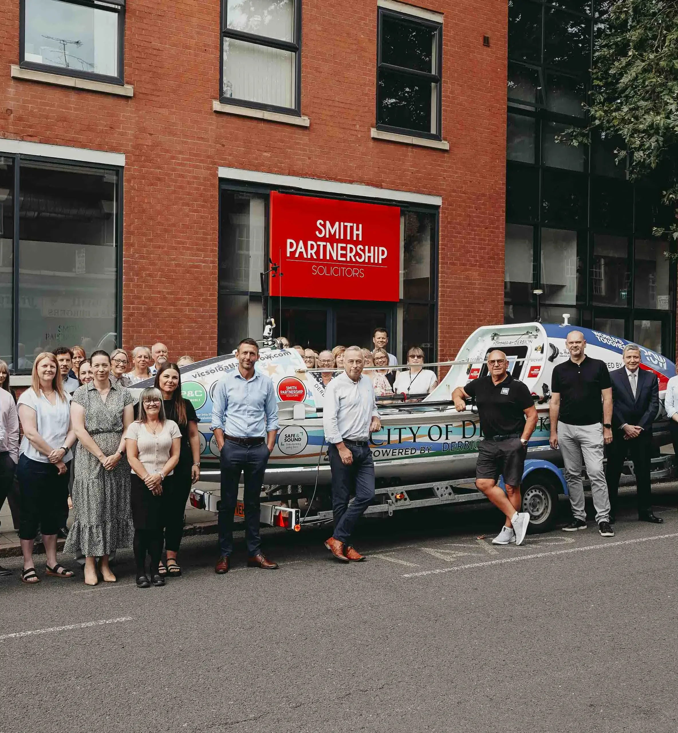 Vic Handley, with boat ‘City of Derby’, at law firm’s head offices in Friar Gate alongside the firm’s Management Committee and Staff