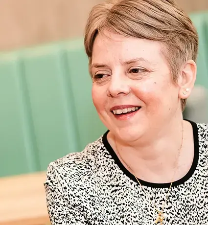 A women is talking to someone across a desk.