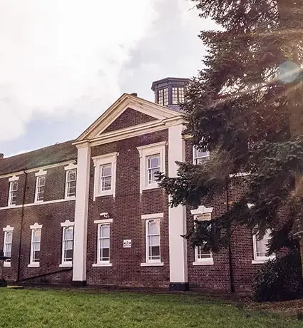 The front of the Stoke-on-Trent Smith Partnership office building, with the sun shining from behind the building.