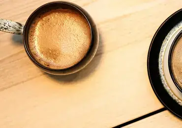 Two coffee cups on a table.