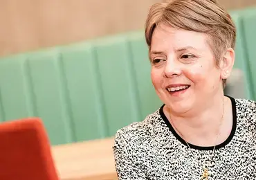 A women is talking to someone across a desk.