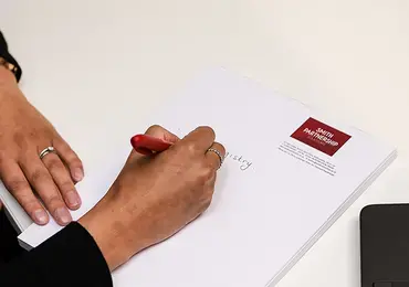 A woman is filling in a Smith Partnership form at a white desk.